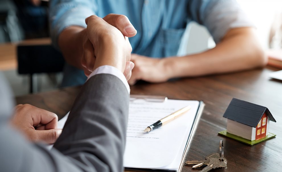 Estate agent shaking hands with his customer after contract signature